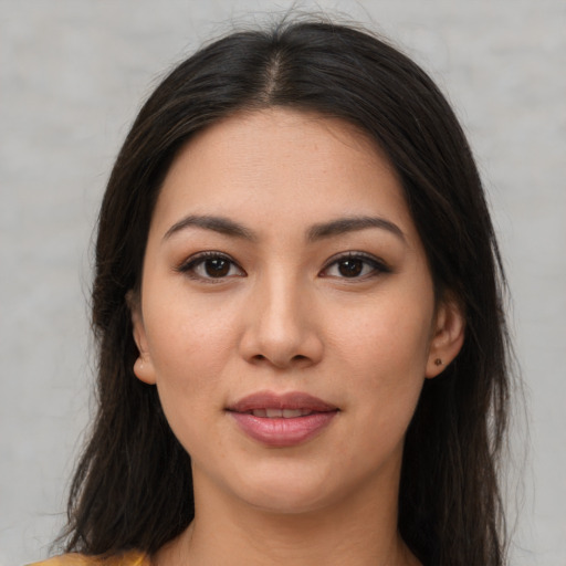 Joyful latino young-adult female with long  brown hair and brown eyes