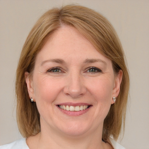 Joyful white adult female with medium  brown hair and blue eyes