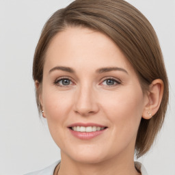 Joyful white young-adult female with medium  brown hair and grey eyes