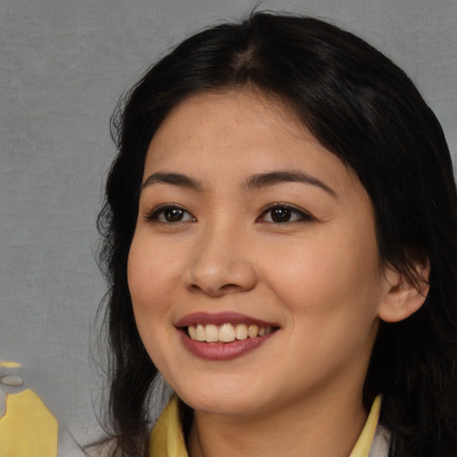 Joyful asian young-adult female with long  brown hair and brown eyes
