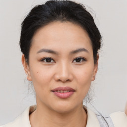 Joyful asian young-adult female with short  brown hair and brown eyes