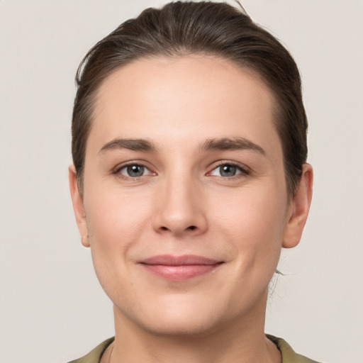 Joyful white young-adult female with short  brown hair and grey eyes