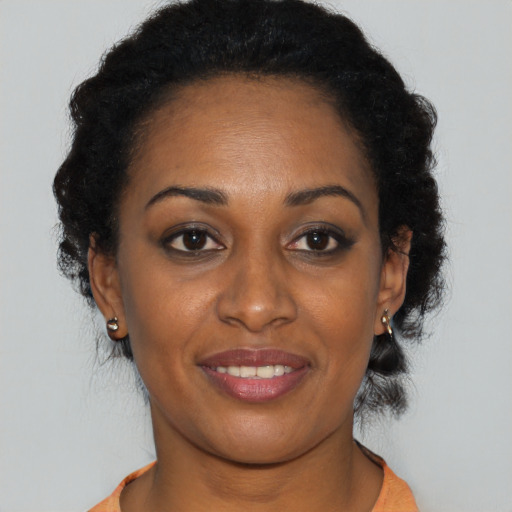 Joyful black young-adult female with short  black hair and brown eyes