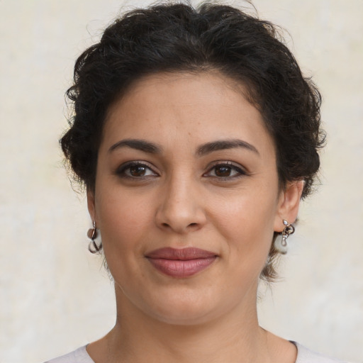 Joyful latino young-adult female with medium  brown hair and brown eyes