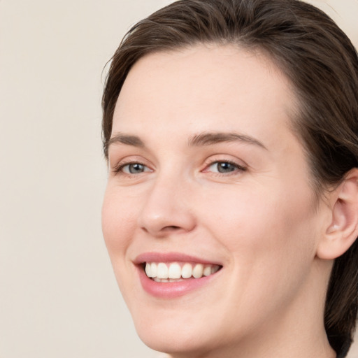 Joyful white young-adult female with medium  brown hair and green eyes