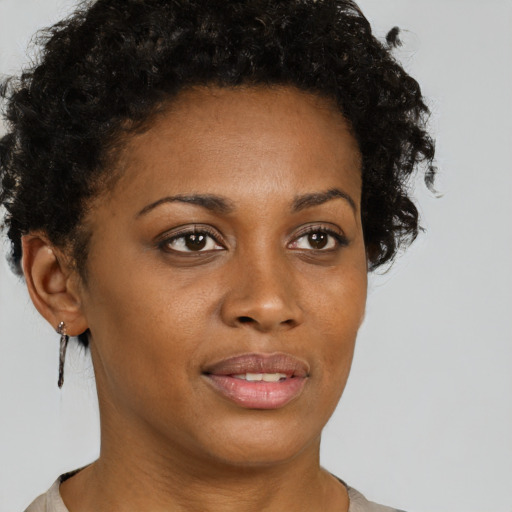 Joyful black young-adult female with short  brown hair and brown eyes