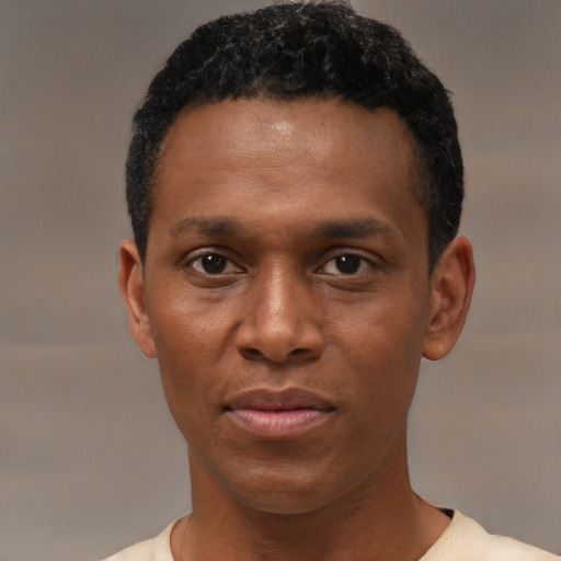 Joyful black young-adult male with short  black hair and brown eyes