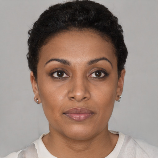 Joyful black young-adult female with short  brown hair and brown eyes