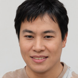 Joyful asian young-adult male with short  brown hair and brown eyes