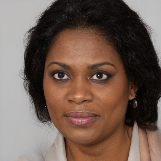 Joyful black young-adult female with long  brown hair and brown eyes