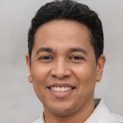 Joyful latino adult male with short  brown hair and brown eyes