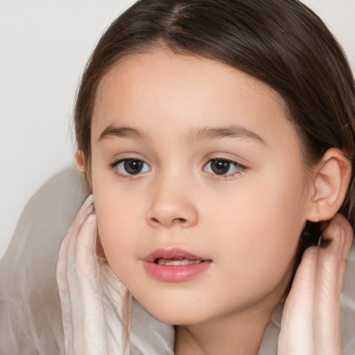 Joyful white child female with medium  brown hair and brown eyes