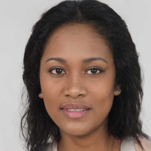 Joyful black young-adult female with long  brown hair and brown eyes