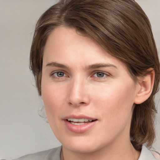 Joyful white young-adult female with medium  brown hair and blue eyes