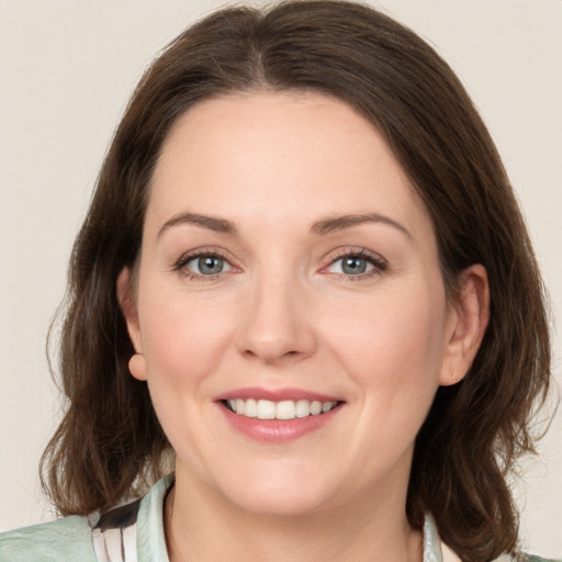 Joyful white young-adult female with medium  brown hair and green eyes