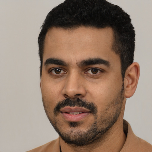 Joyful latino young-adult male with short  black hair and brown eyes