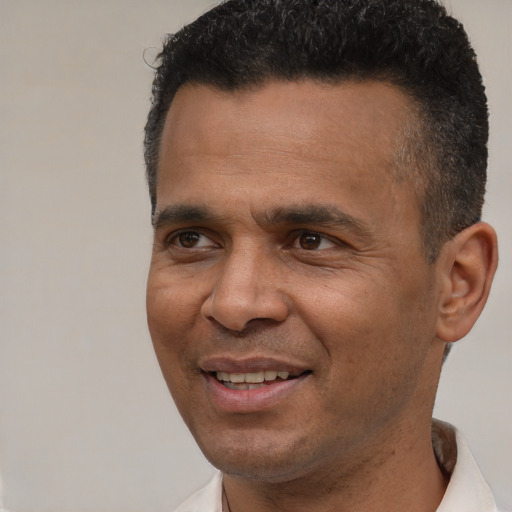 Joyful latino adult male with short  black hair and brown eyes