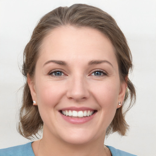 Joyful white young-adult female with medium  brown hair and grey eyes