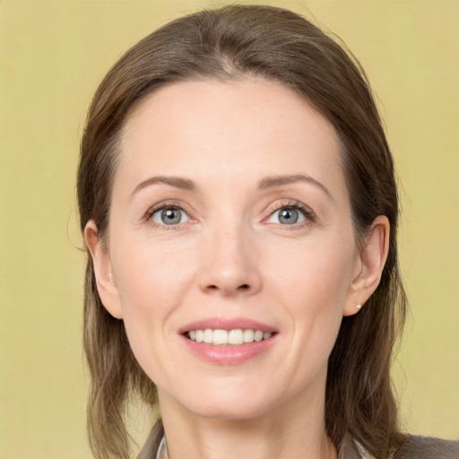 Joyful white young-adult female with long  brown hair and grey eyes