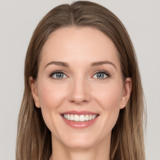 Joyful white young-adult female with long  brown hair and grey eyes