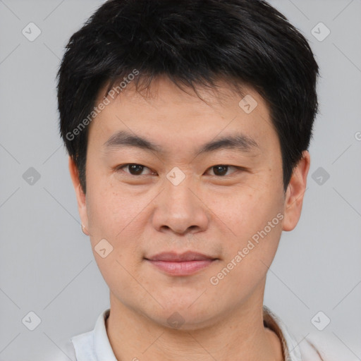 Joyful asian young-adult male with short  black hair and brown eyes