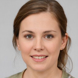 Joyful white young-adult female with medium  brown hair and green eyes