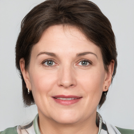 Joyful white adult female with medium  brown hair and grey eyes