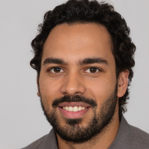 Joyful latino young-adult male with short  black hair and brown eyes