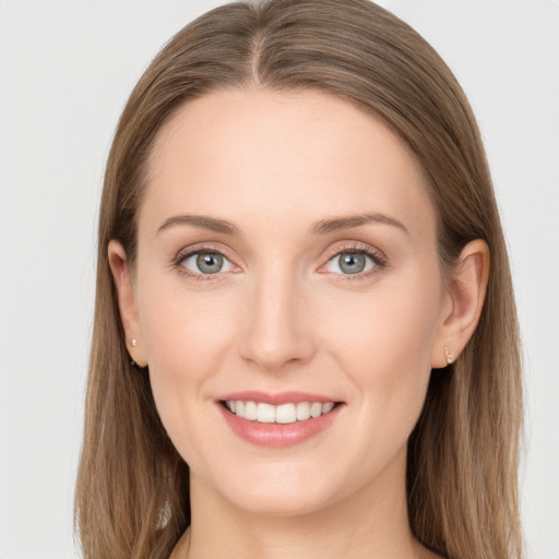 Joyful white young-adult female with long  brown hair and grey eyes