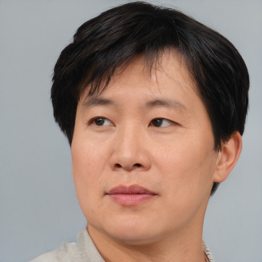 Joyful asian adult male with short  brown hair and brown eyes