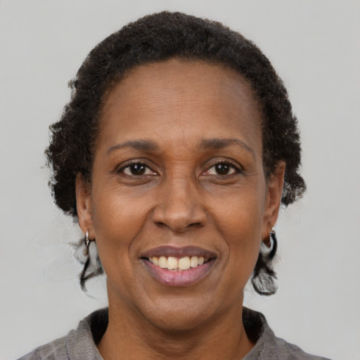Joyful black adult female with short  brown hair and brown eyes