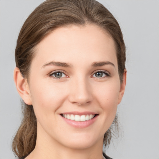 Joyful white young-adult female with medium  brown hair and grey eyes