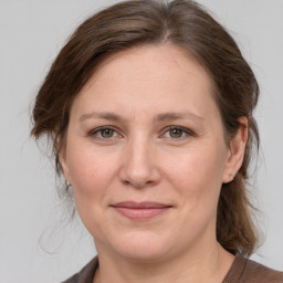 Joyful white adult female with medium  brown hair and grey eyes