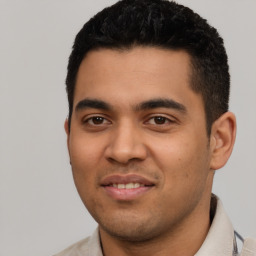 Joyful latino young-adult male with short  black hair and brown eyes