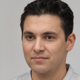 Joyful white young-adult male with short  black hair and brown eyes