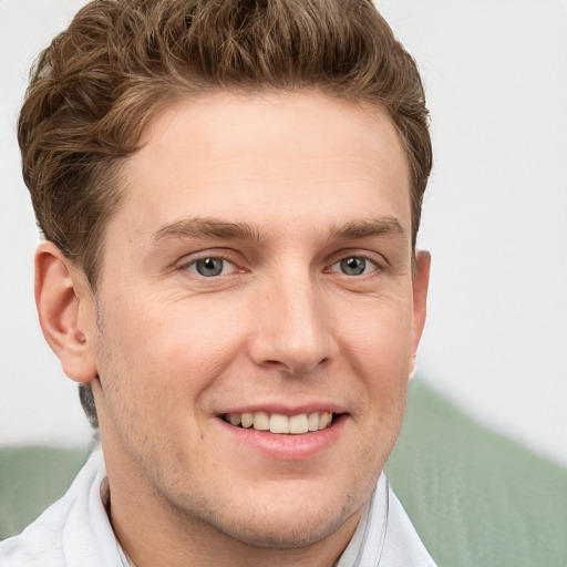 Joyful white young-adult male with short  brown hair and grey eyes