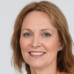 Joyful white adult female with medium  brown hair and grey eyes