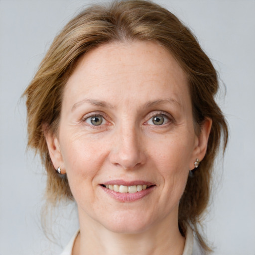 Joyful white adult female with medium  brown hair and grey eyes