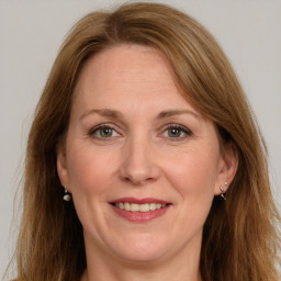 Joyful white adult female with long  brown hair and grey eyes