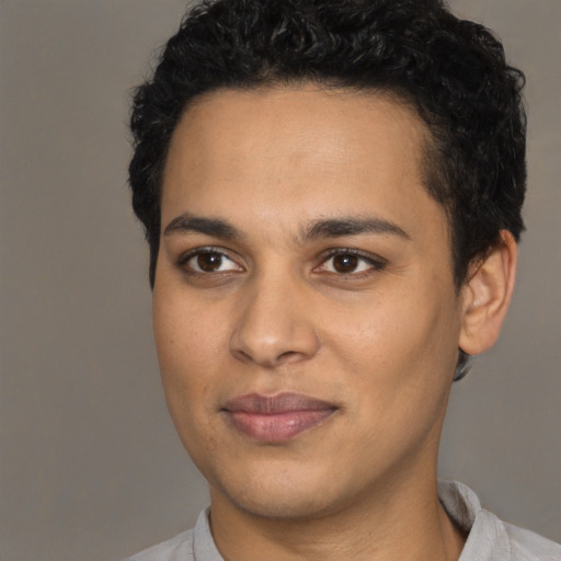 Joyful latino young-adult male with short  brown hair and brown eyes