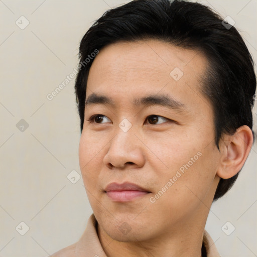 Joyful asian young-adult male with short  black hair and brown eyes