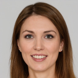 Joyful white young-adult female with long  brown hair and brown eyes