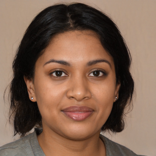 Joyful black young-adult female with medium  black hair and brown eyes