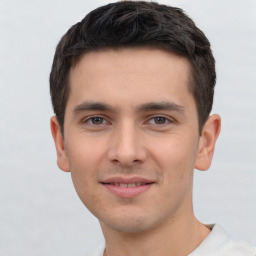 Joyful white young-adult male with short  black hair and brown eyes