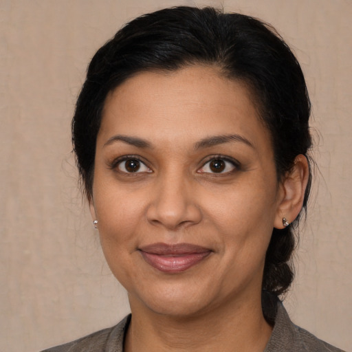 Joyful latino adult female with medium  brown hair and brown eyes