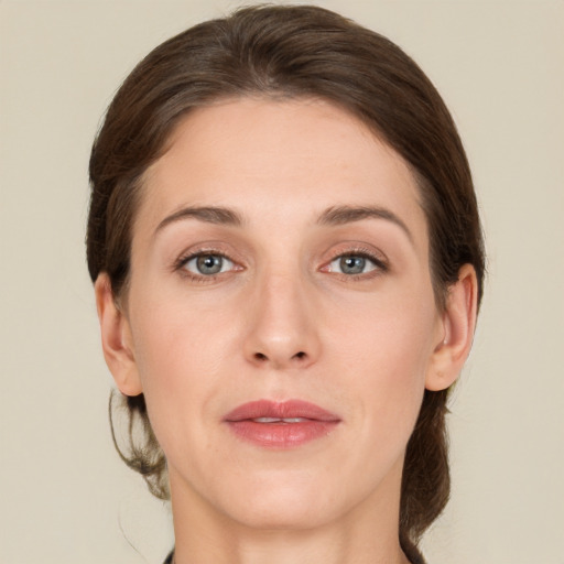 Joyful white young-adult female with medium  brown hair and grey eyes