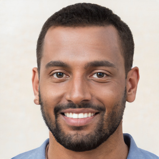 Joyful black young-adult male with short  black hair and brown eyes