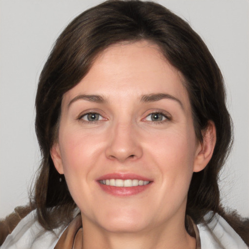 Joyful white adult female with medium  brown hair and grey eyes