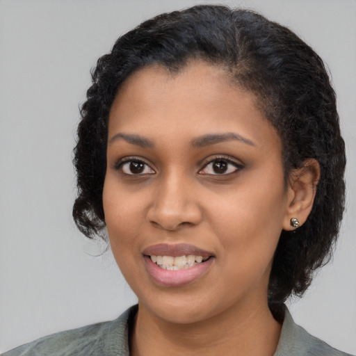 Joyful black young-adult female with medium  black hair and brown eyes