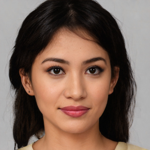 Joyful latino young-adult female with medium  brown hair and brown eyes